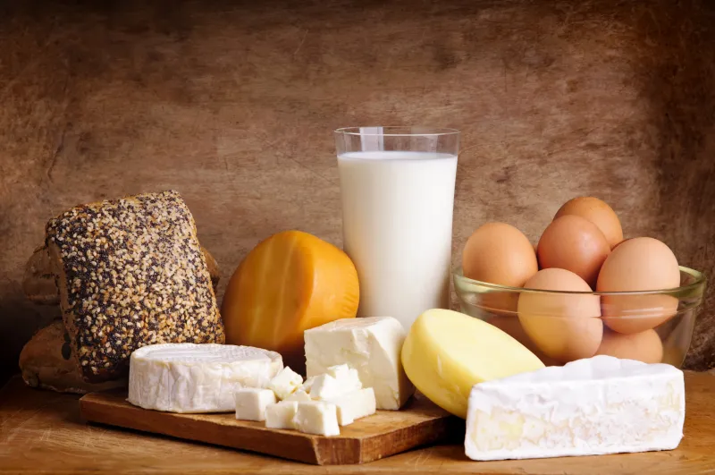 Glass of milk, eggs, and cheese on a table