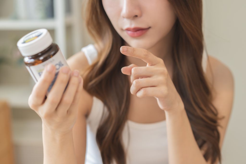Woman reading supplement label