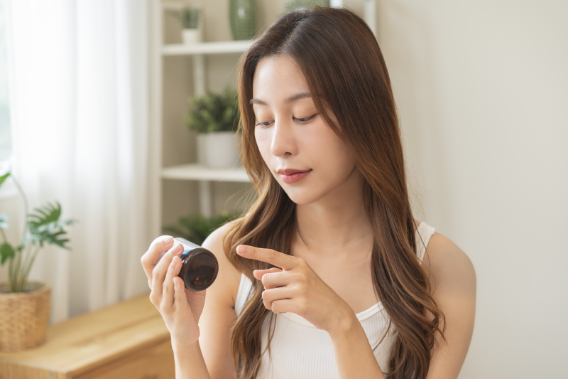 Woman reading supplement label
