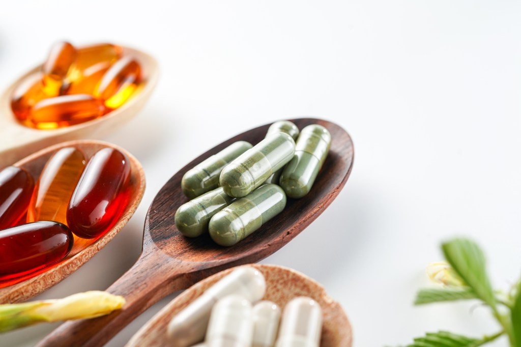 Various supplement capsules on spoons