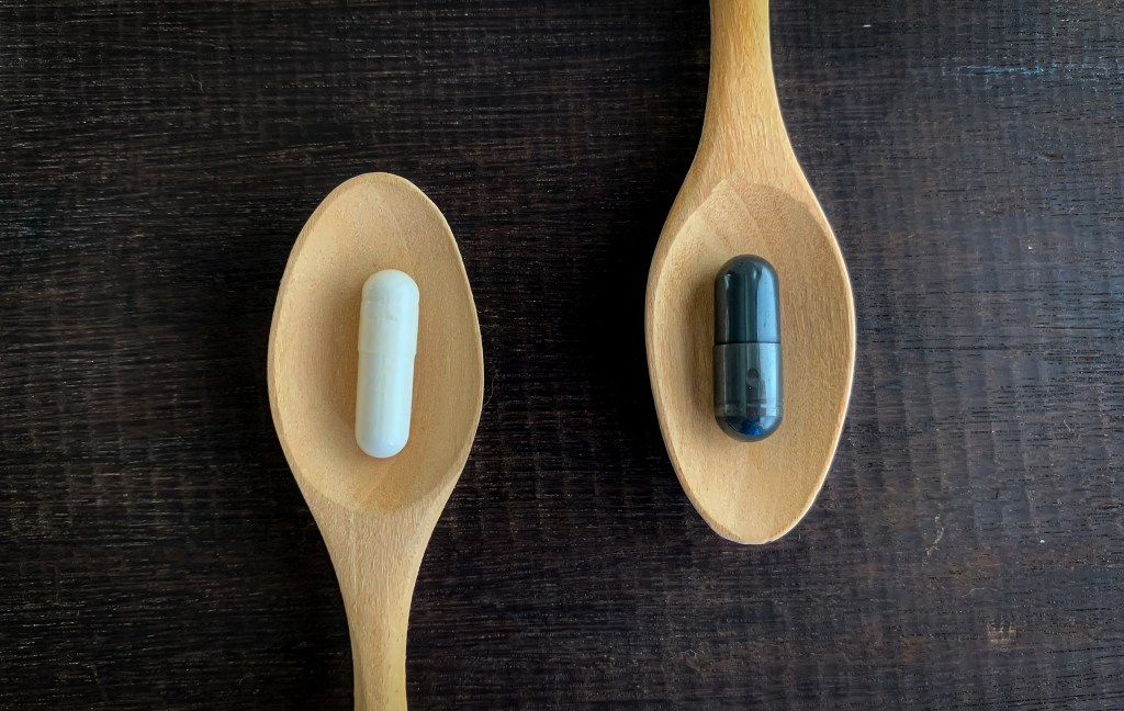Different pills on wooden spoons