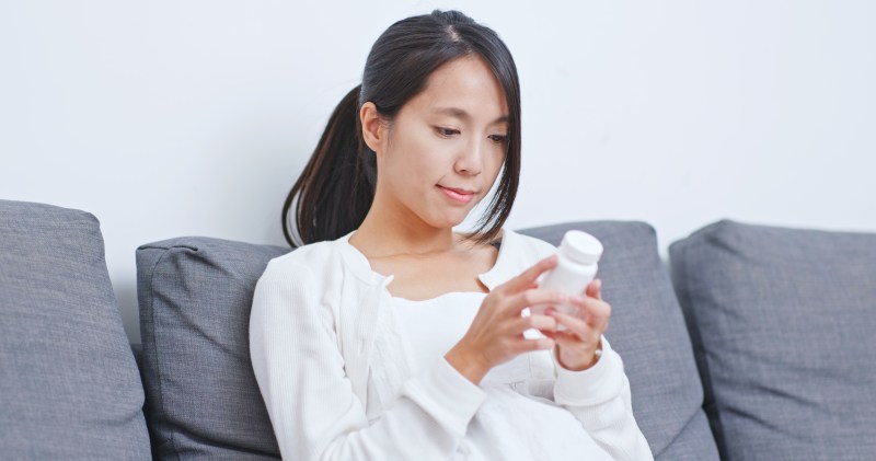 Woman checking supplement label
