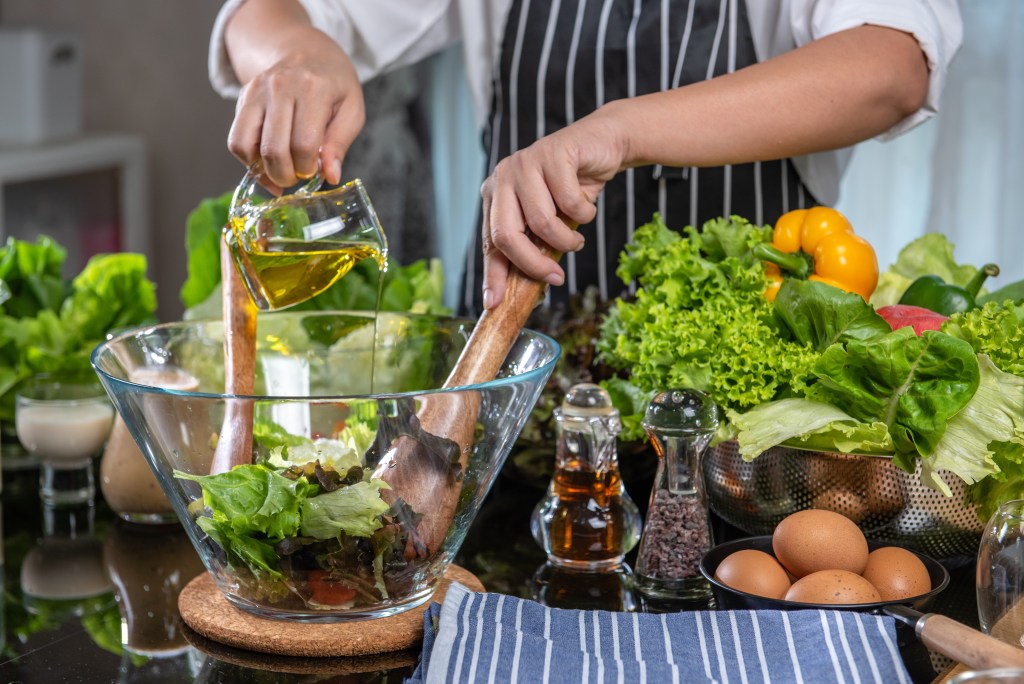 Pouring oil over salad