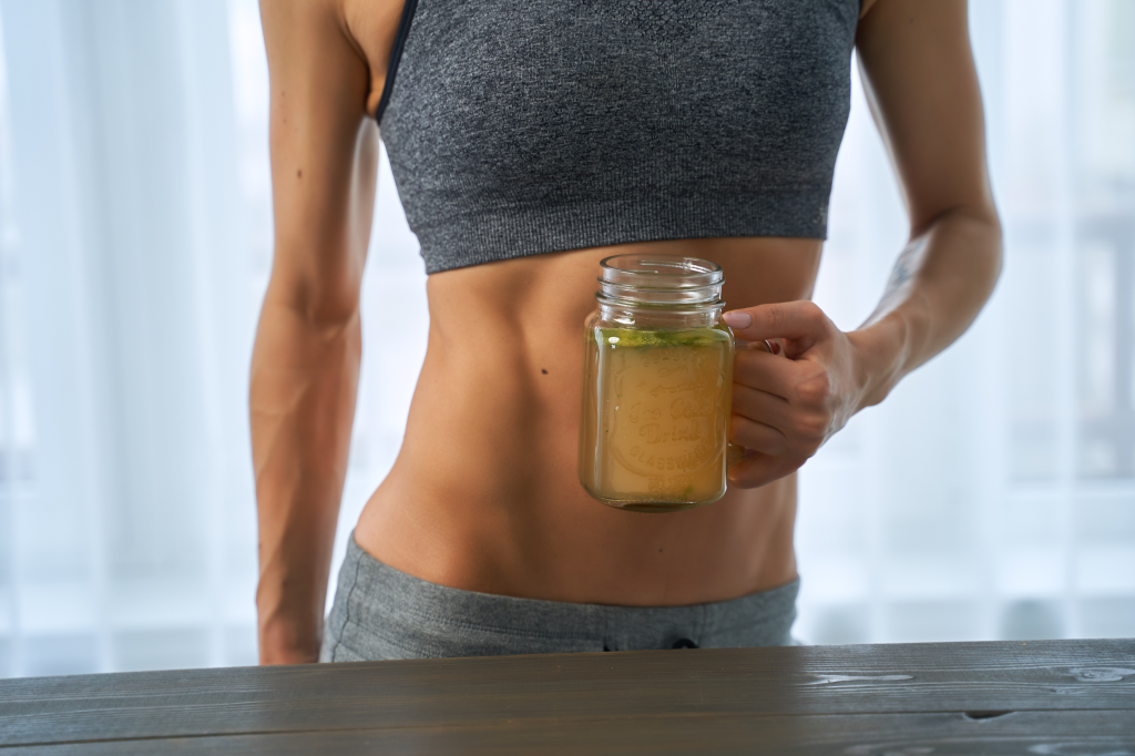 Woman holding glass of broth