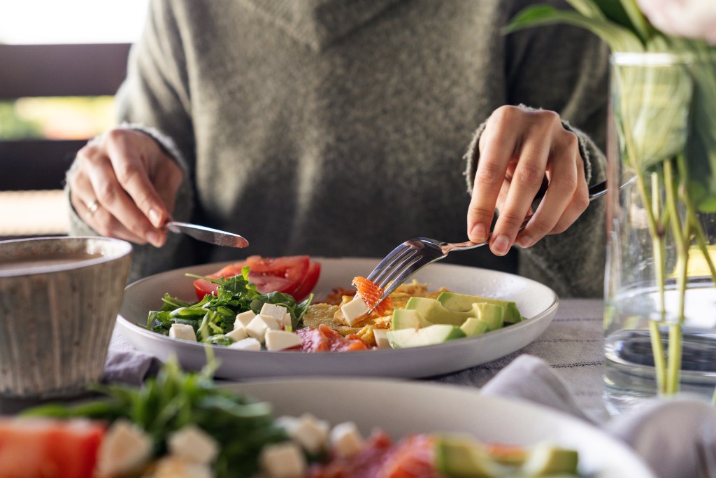 Eating feta-topped keto salad