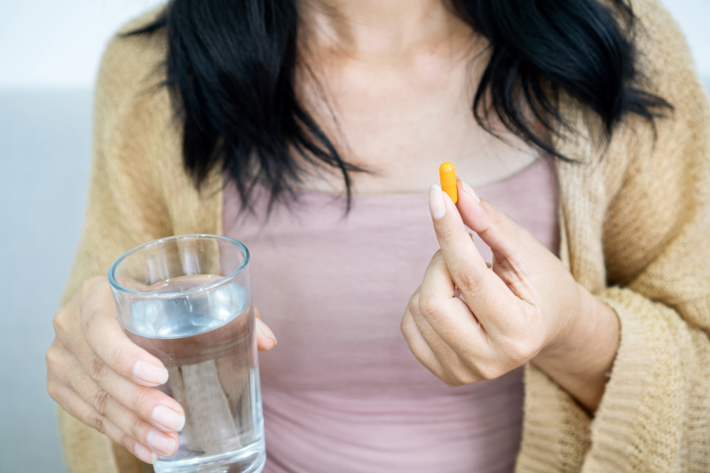 Woman taking turmeric pill