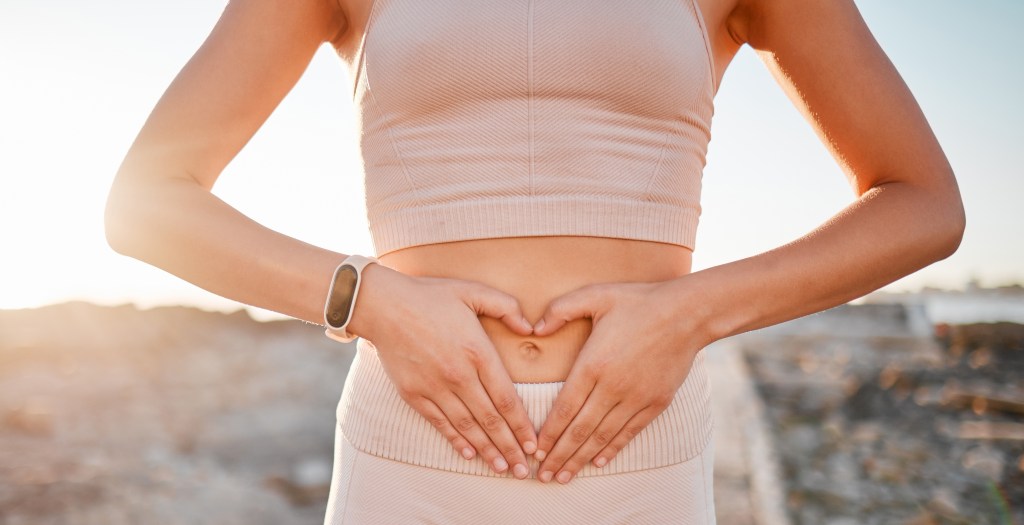 Woman making a heart with her hands on her stomach