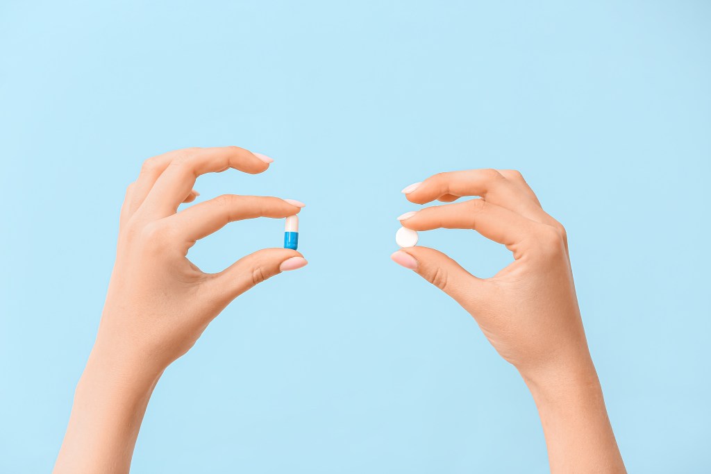 Hands holding different pills