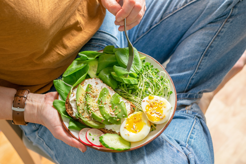 Woman eating salad with healthy fats