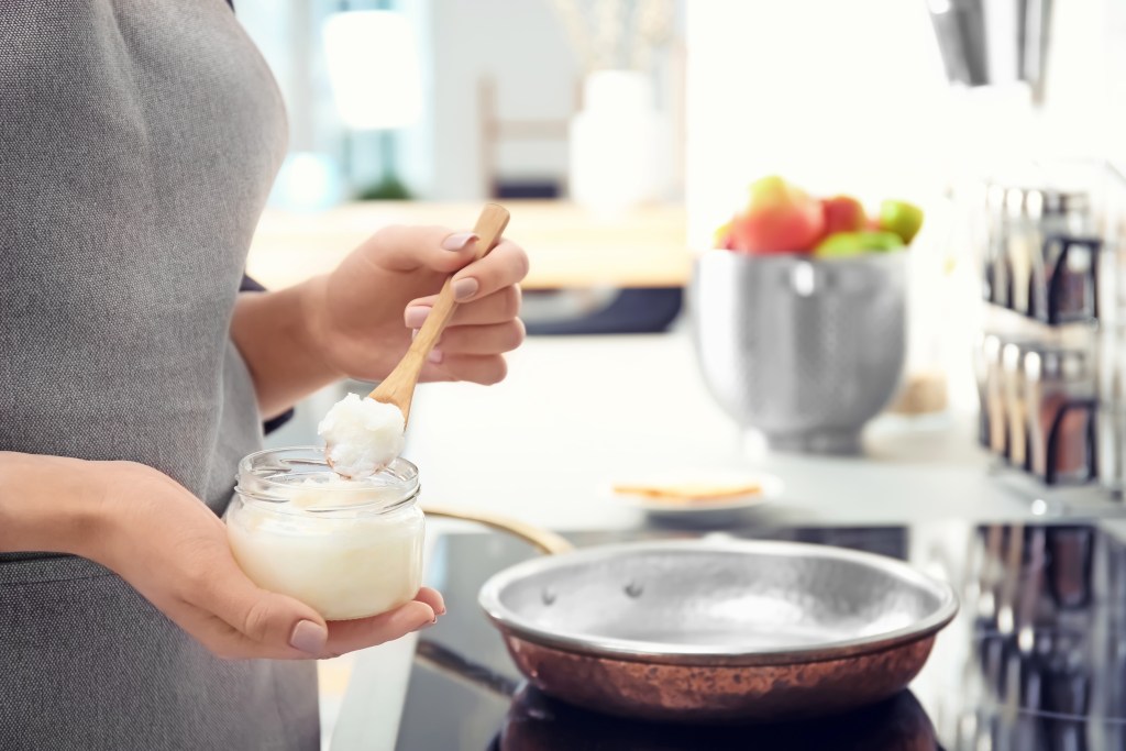 Woman cooking with coconut oil 