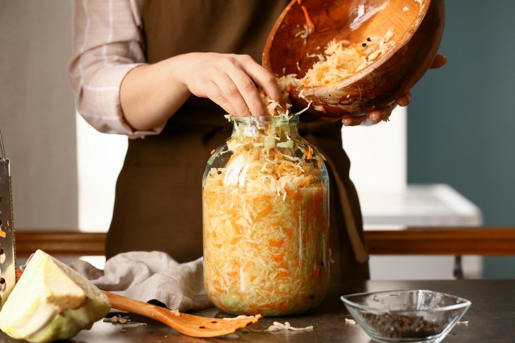Woman pouring sauerkraut into a jar