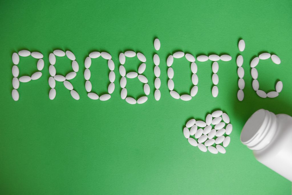 Probiotic pills on green background 