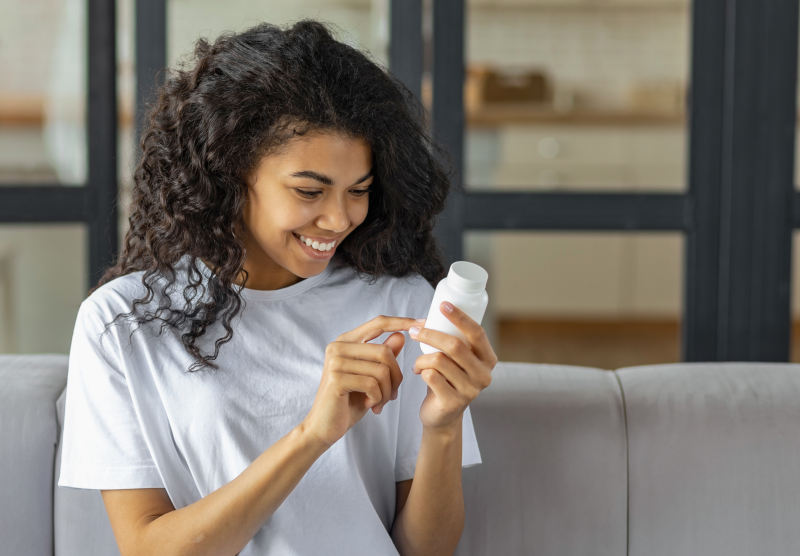 Woman holding a supplement container
