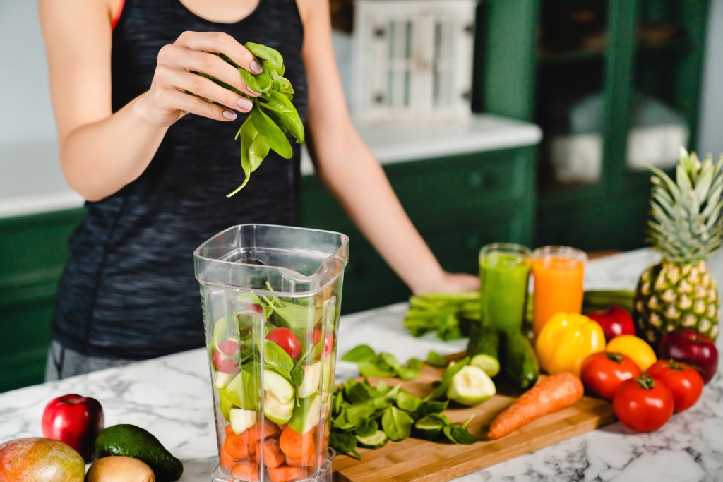 Woman preparing a green smoothie