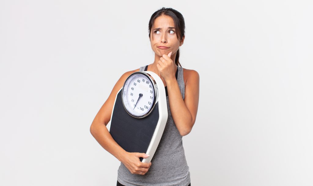 Young woman holding scale