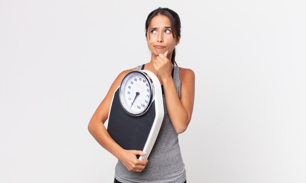 Young woman holding scale
