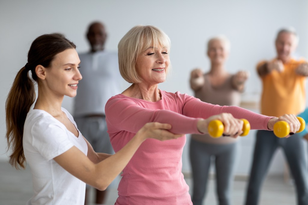 Older woman exercising with trainer