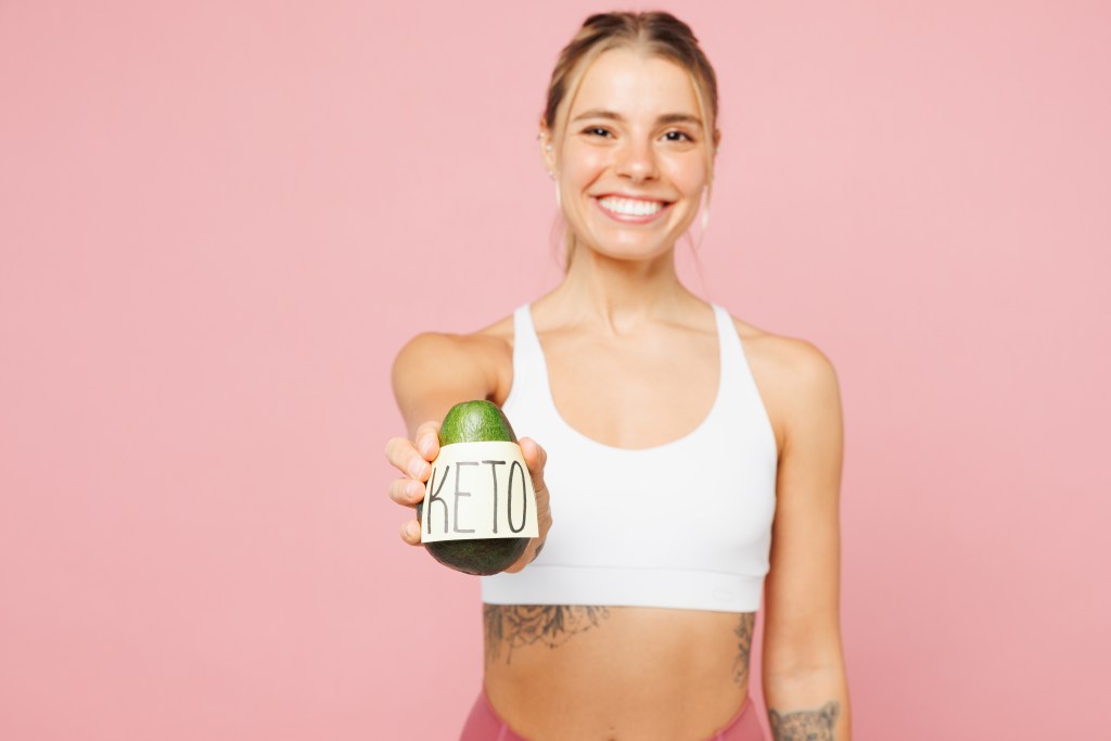 fit woman holding keto avocado