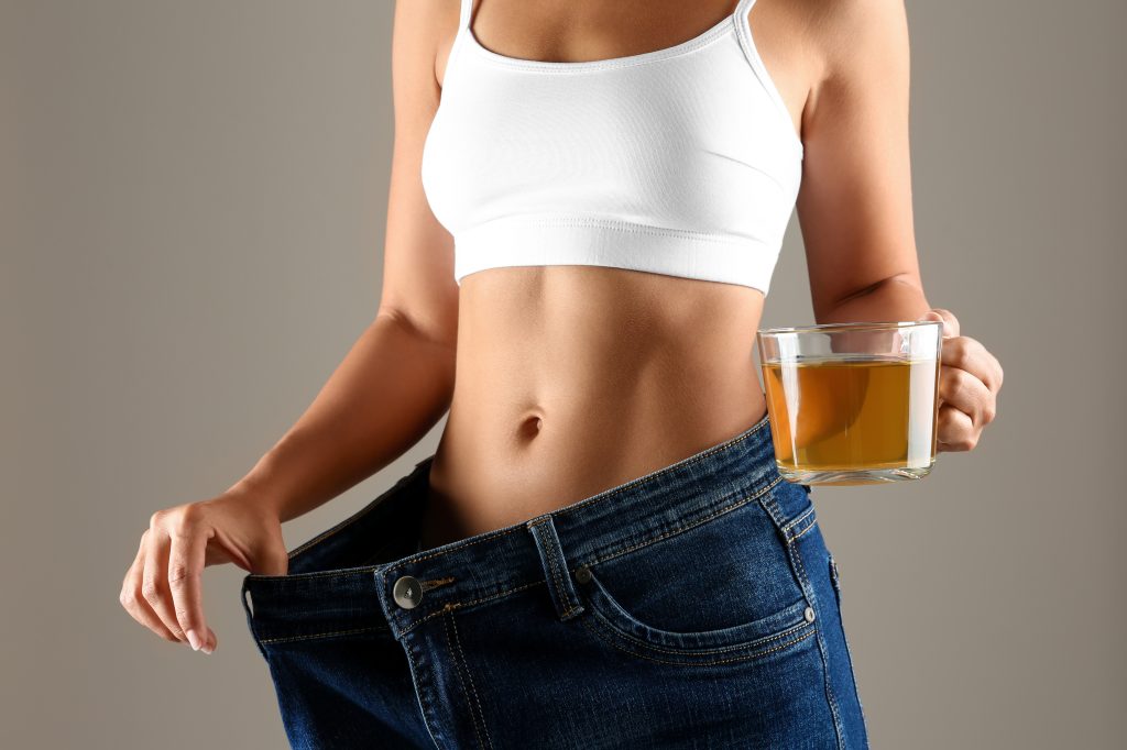woman losing weight with a cup of tea one of Health Benefits of Green Tea
