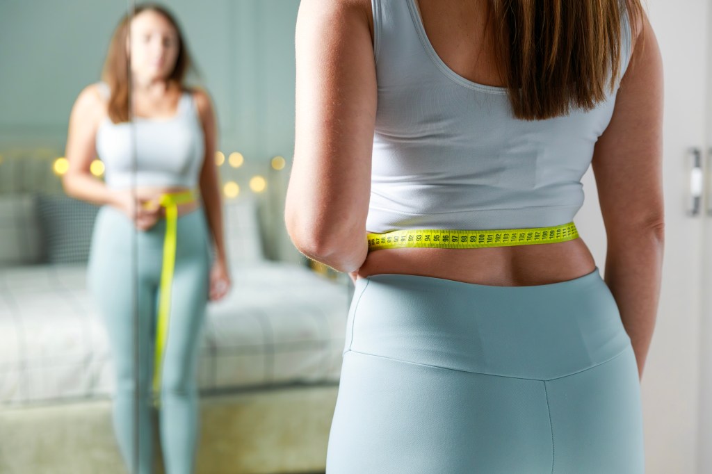 Woman measuring her waist