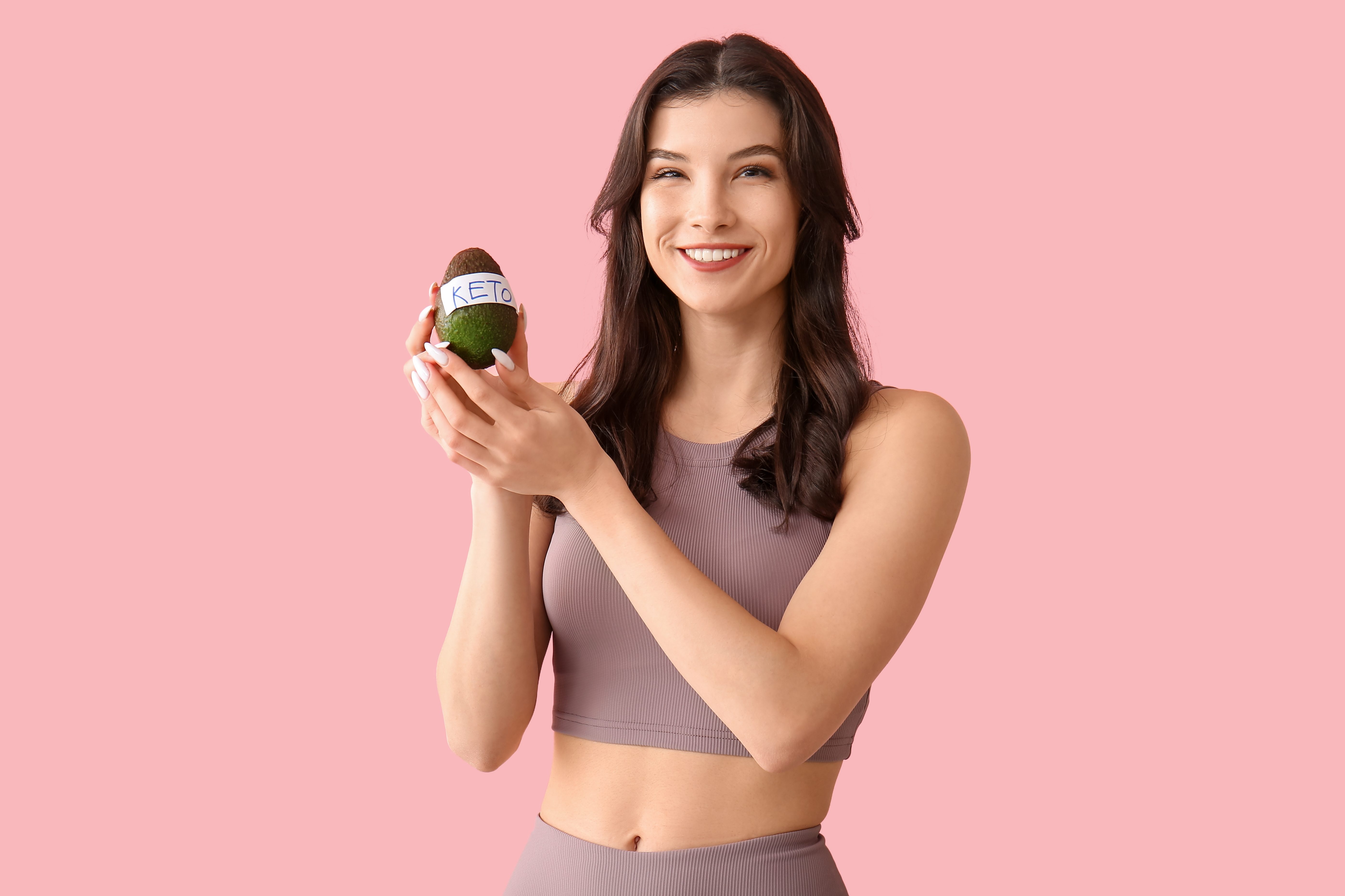 Woman holding avocado with keto label
