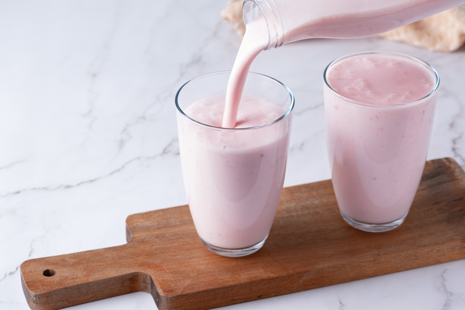 Pouring berry kefir into a glass