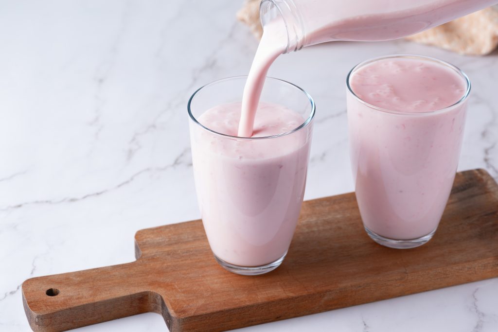 Pouring berry kefir into a glass