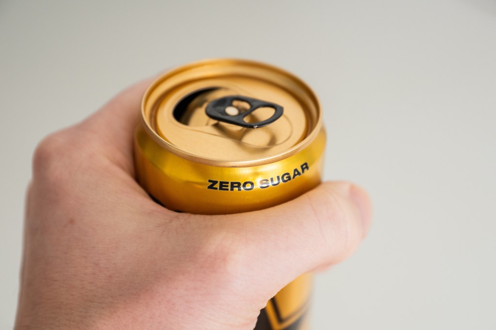 Hand holding a diet soda