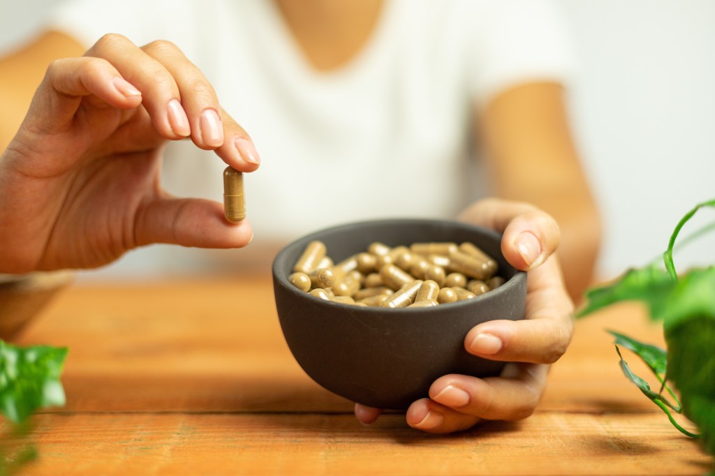 Woman holding an ashwagandha capsule