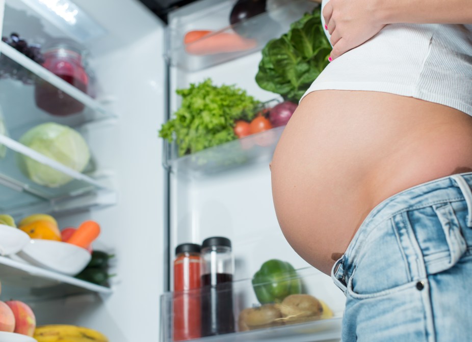 Pregnant woman in front of fridge 