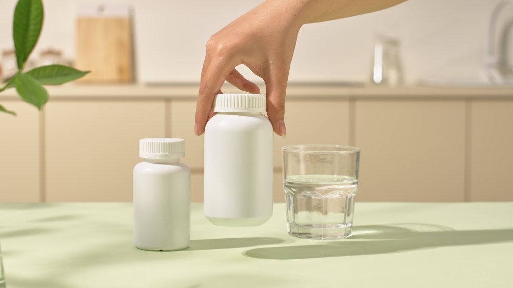 Hand grabbing a supplement bottle
