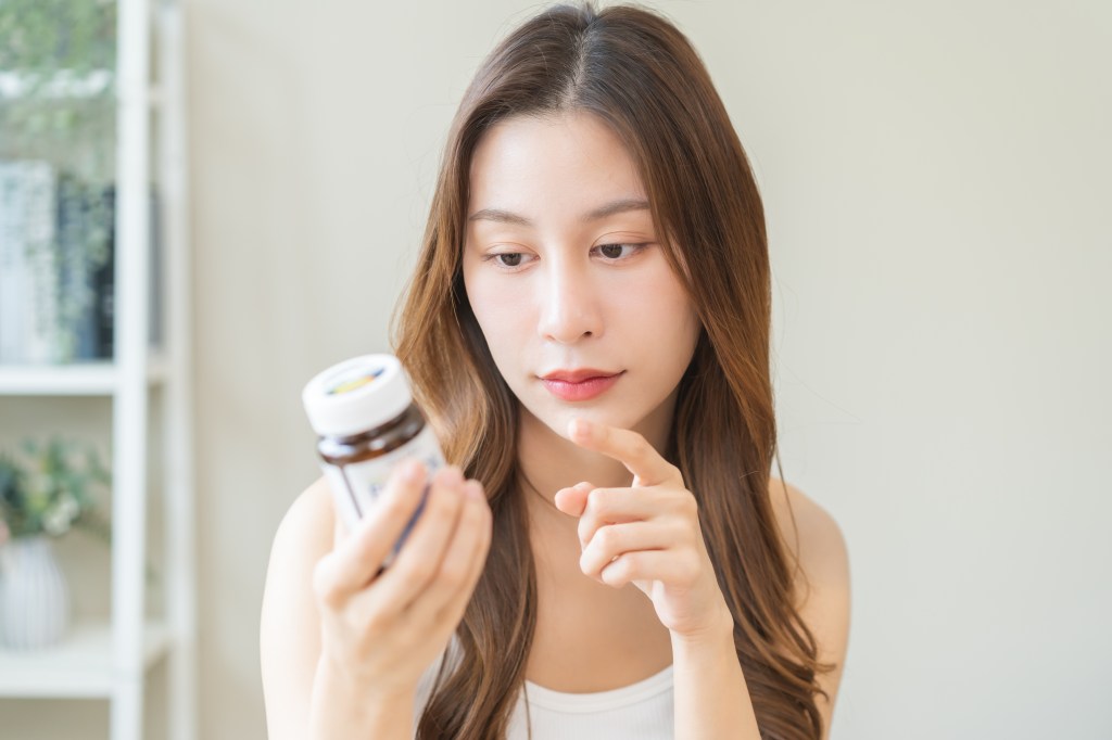 Woman reading supplement label  