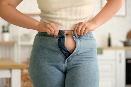 Woman trying to button pants