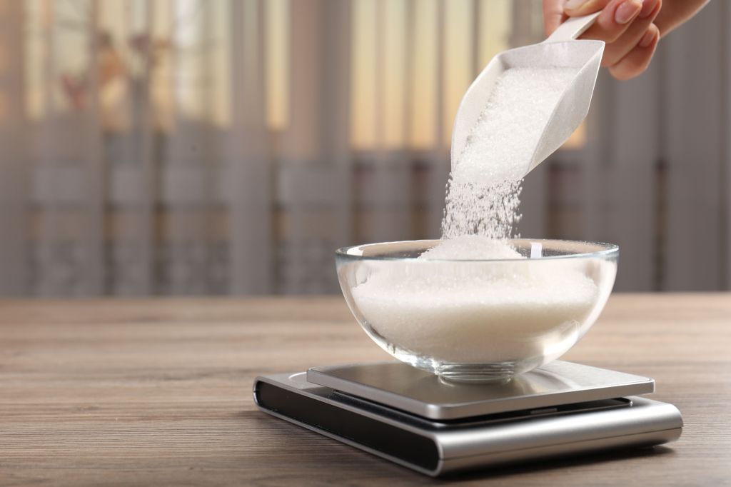 Adding sugar to a bowl