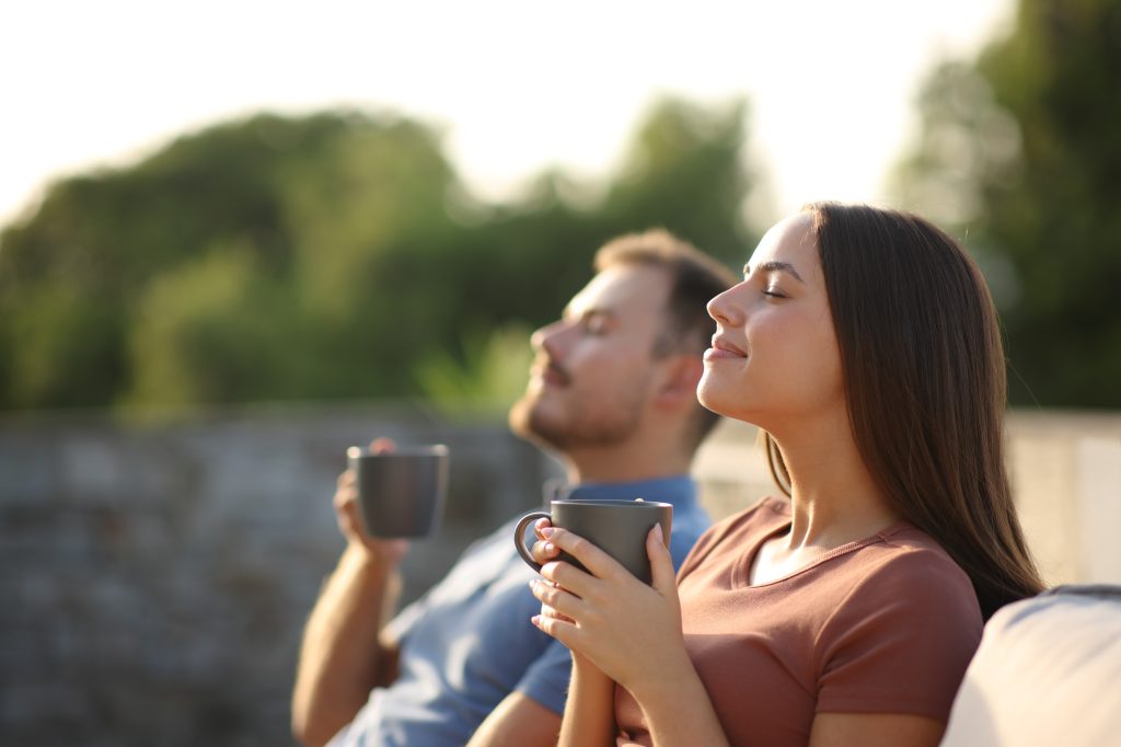 Couple enjoying early morning coffee outside