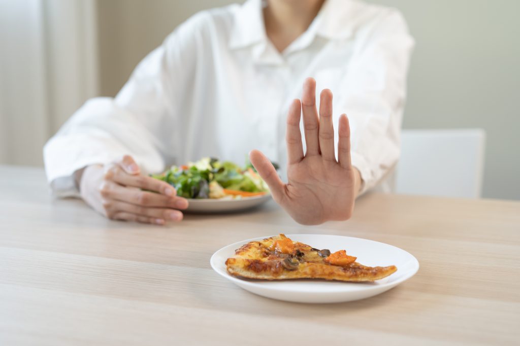 Woman refusing a plate of food