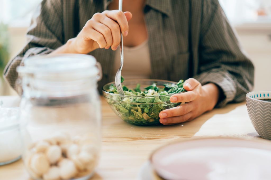 Woman eating a bowl of greens