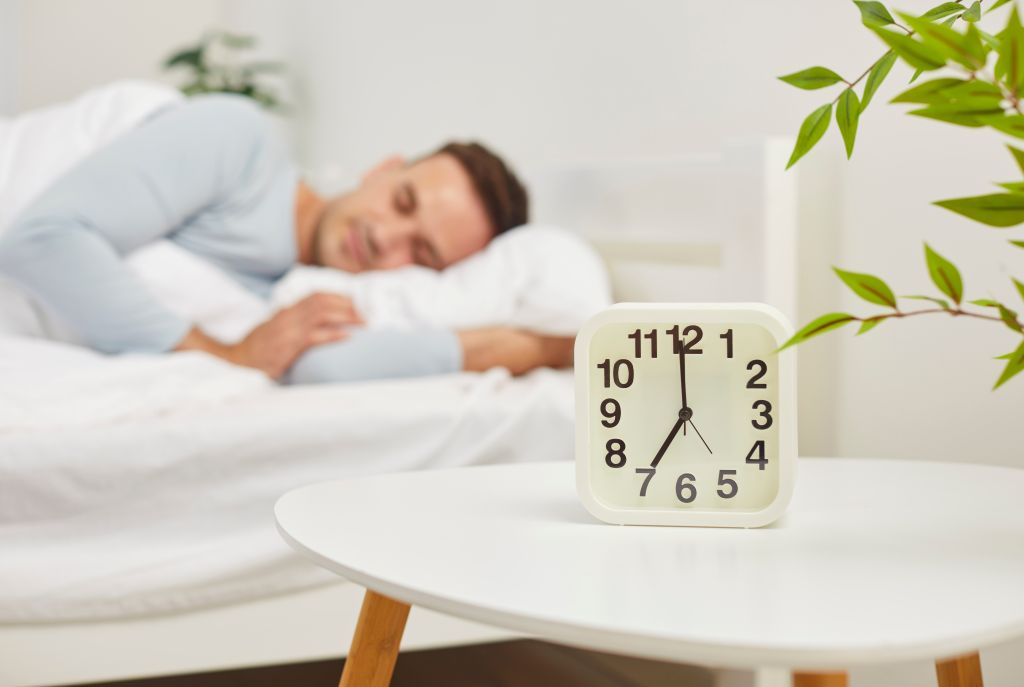 Alarm clock and a sleeping man